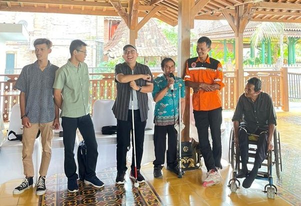 Peserta penyandang disabilitas ikut serta dalam pelatihan. Tampak seorang laki-laki menggunakan kursi roda di ujung kanan, kemudian seorang laki-laki yang memegang mikrofon menggunakan tongkat penyangga yang sedang berdiskusi untuk menjawab pertanyaan dari fasilitator, di sebelah kirinya seorang laki-laki menggunakan kacamata dan tongkat tunanetra (yang berfungsi untuk memandu dalam berjalan)