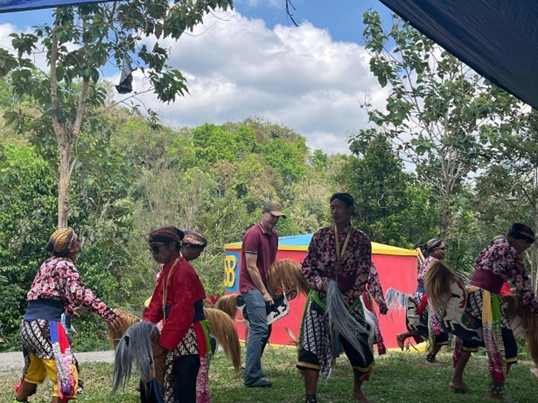 Alt.Teks: Sekelompok penari laki-laki dari kesenian tari Laras Budoyo menampilkan tarian khas nya dengan mengenakan baju adat juga kuda lumping sebagai aksesoris tari tersebut.