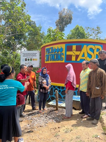 Peresmian water system yang diwakilkan oleh 2 orang perempuan yang mengenakan jilbab untuk membuka keran sebagai simbol dari peresmian ini yang dilakukan tepat di depan penampungan air Desa Ngadiharjo dan dikelilingi oleh beberapa orang yang ikut serta menyaksikan simbolis peresmian tersebut.